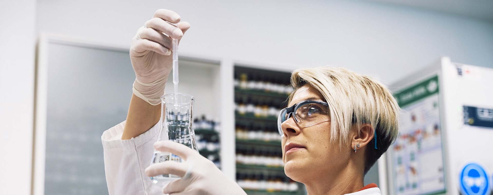 Laborarbeiterin hält ein Reagenzglas in der Hand und stellt Arzneimittel her